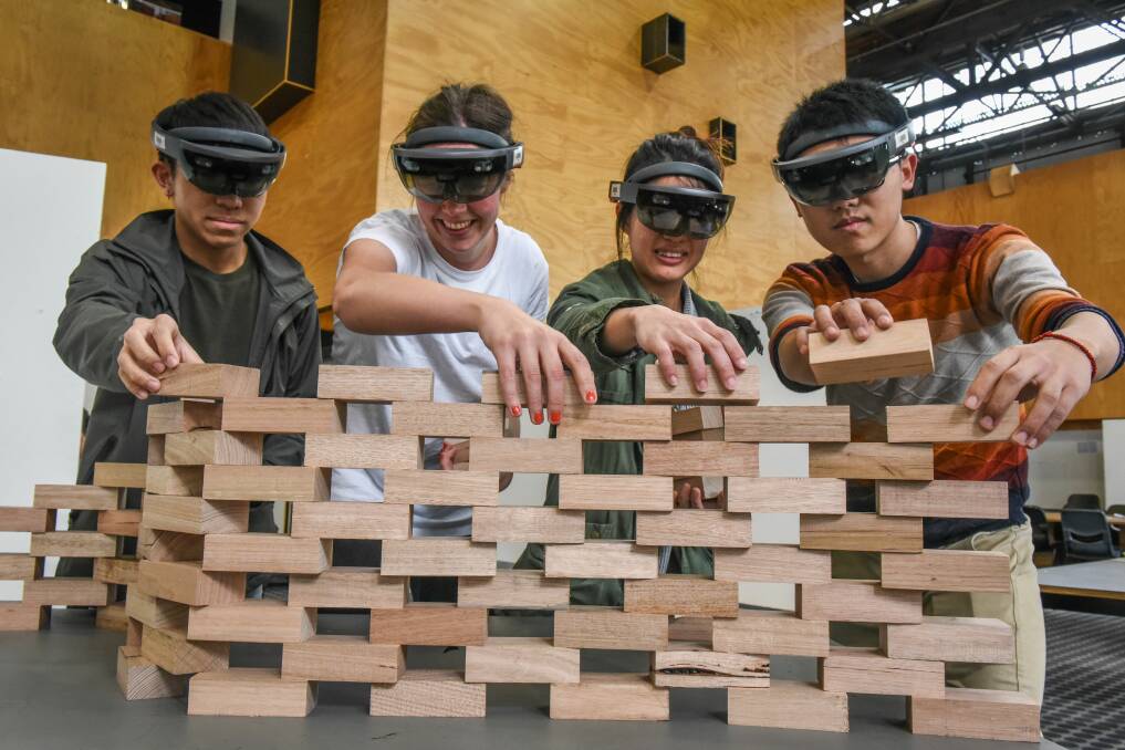 UTAS Master of Architecture students Tommy Yeo, Kathrine Vand, Stephanie Chin, and Guangwen Chen using augmented reality to build a complex brick structure. Picture: Paul Scambler.