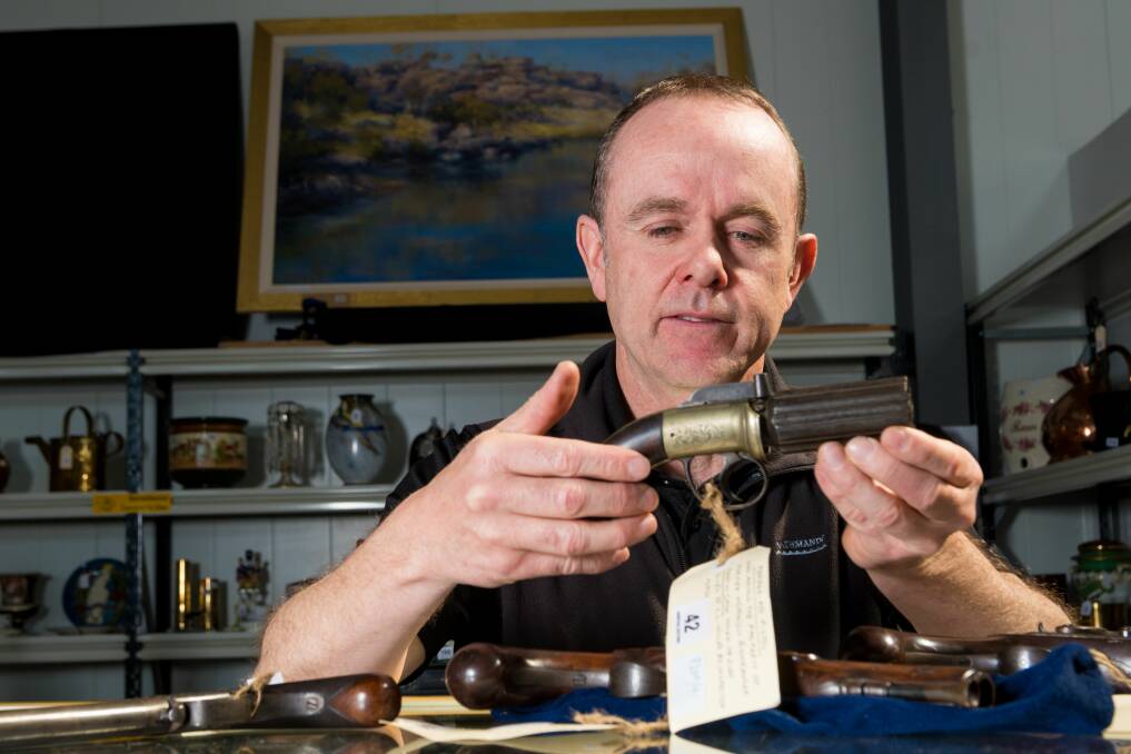 COLLECTED: Auctioneer Neil O'Brien with a pistol owned by bushranger Martin Cash. Picture: Phillip Biggs