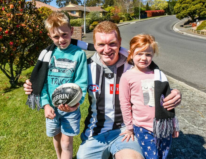 Collingwood supporter of 30 years Chris Pickering with Harry, 8, and Lucy, 5. Picture: Neil Richardson