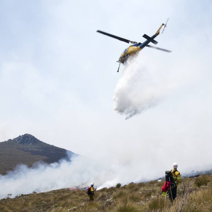 Waterbombing aircraft saturate the fire edge as ground crews extinguish the remnants with hand tools. Picture: Warren Frey (supplied by TFS)
