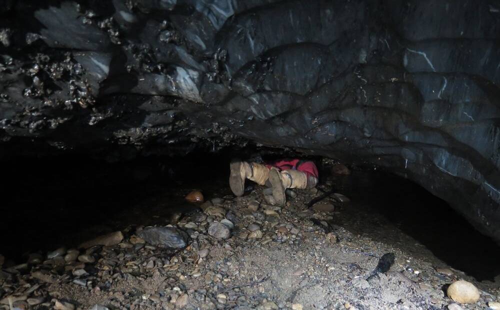 David Butler squeezes into a cave at Mole Creek. Picture: Michal Ciszewsk