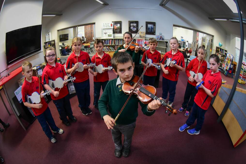 PITCHING IN: Solly Fletcher, 8, surrounded by Invermay Primary School students learning to play the violin. Picture: Paul Scambler