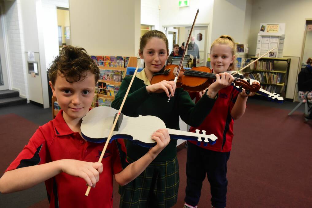 PLUCKED: Invermay Primary School student Louis Everall, 9, Maddy Fletcher, 10, of St Finn Barr's Catholic Primary School, and Invermay Primary School student Mia Austin, 8, practice their new violin skills. Picture: Paul Scambler
