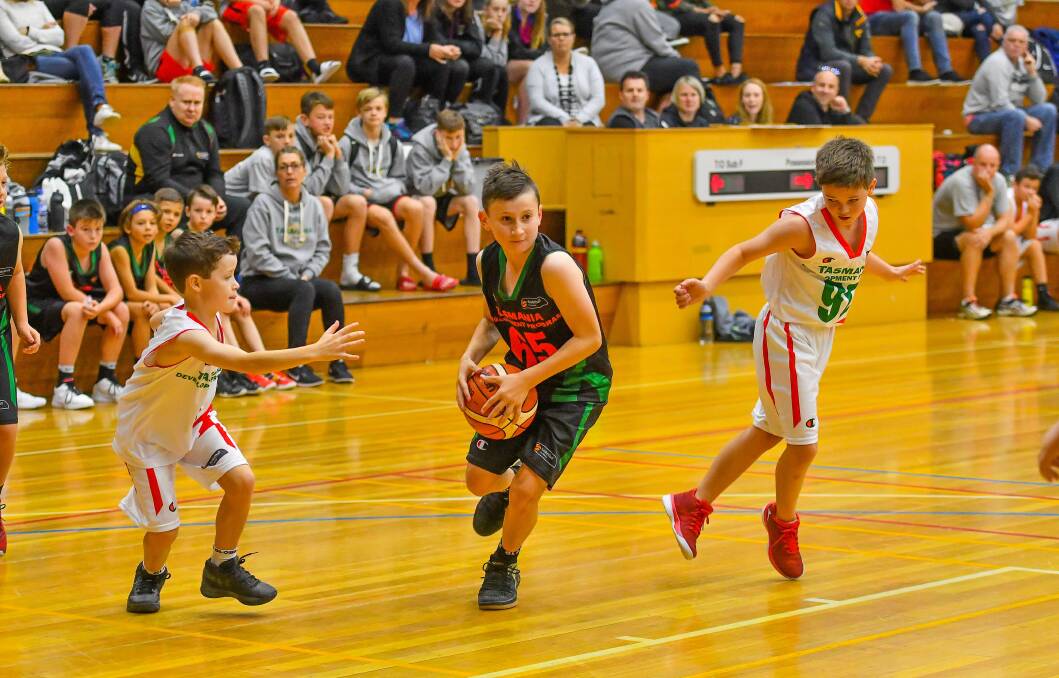 FAST BREAK: Jackson Reece looks to run away for North West Black from his South Green opponents.