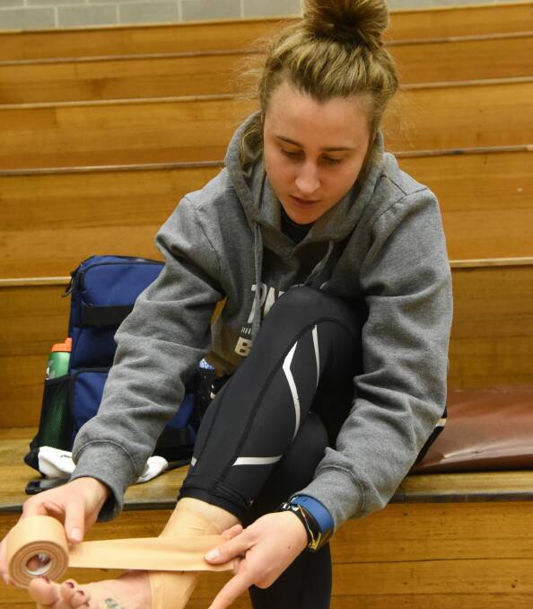 PREPARATION: Lauren Mansfield returns to the familiar sight recently of strapping her injured ankle. Pictures: Paul Scambler