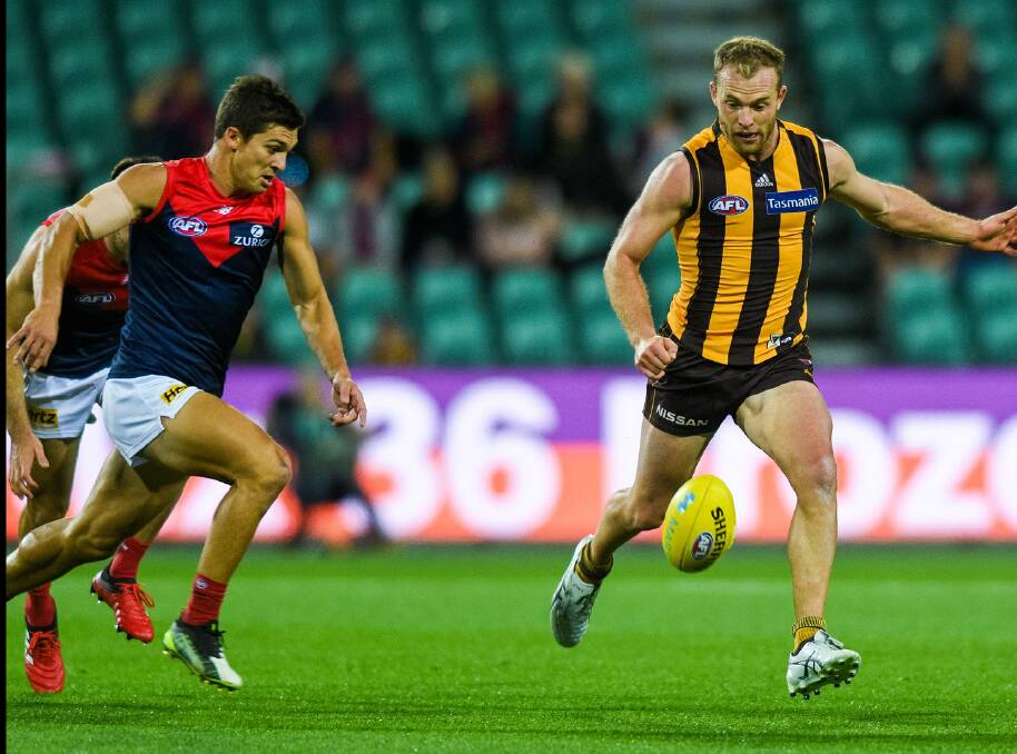 GUTS AND GLORY: Jay Lockhart shows off a determination to run down Brownlow Medallist Tom Mitchell in this year's preseason return to UTAS Stadium. Picture: Phillip Biggs