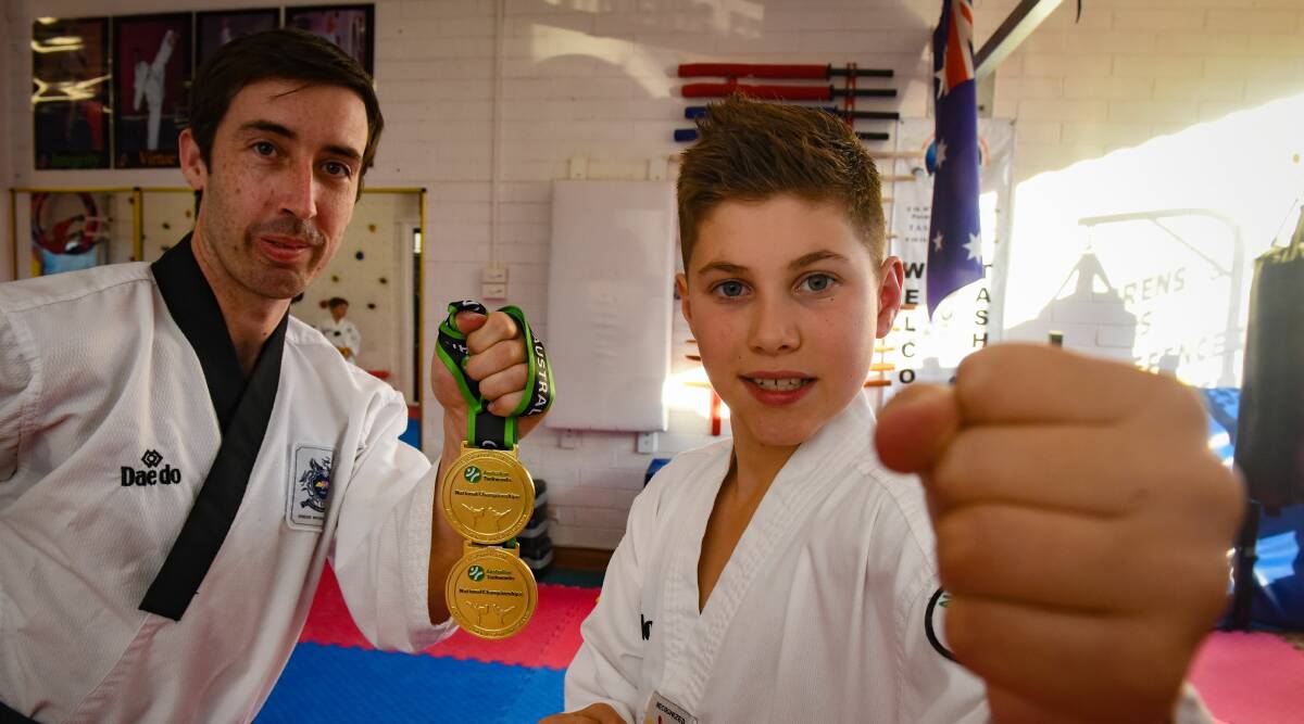 FIGHT: Master instructor Joshua Warren shows off the taekwondo national gold medals of his prized student Sebastian Oliver. Picture: Paul Scambler