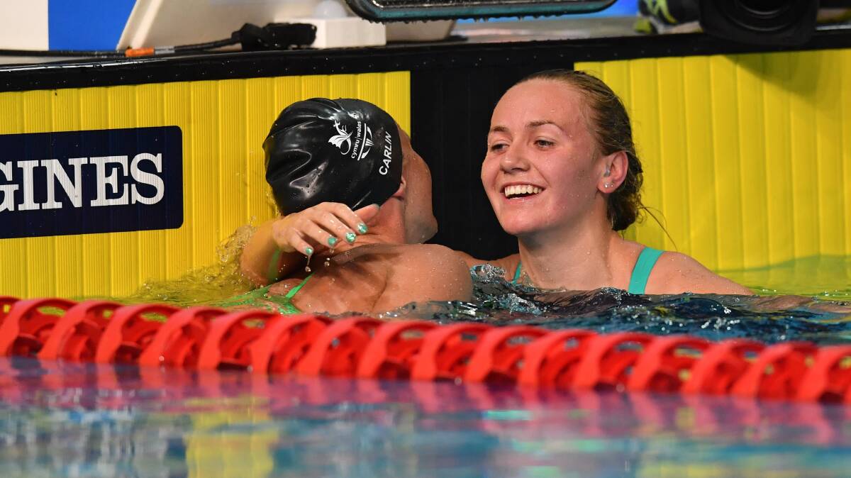 DELIGHTED: Ariarne Titmus is hugged by Welsh swimmer Jazmin 
Carlin after the Tasmanian collected Commonwealth Games gold in 
the women's 800m freestyle final on Monday night. Picture: AAP