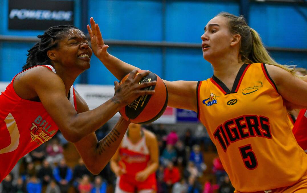 COP THAT: Courtney Williams gets a taste of her first game in Tornadoes colours with a hand in the face from Melbourne Tiger Kasey Burton. 
