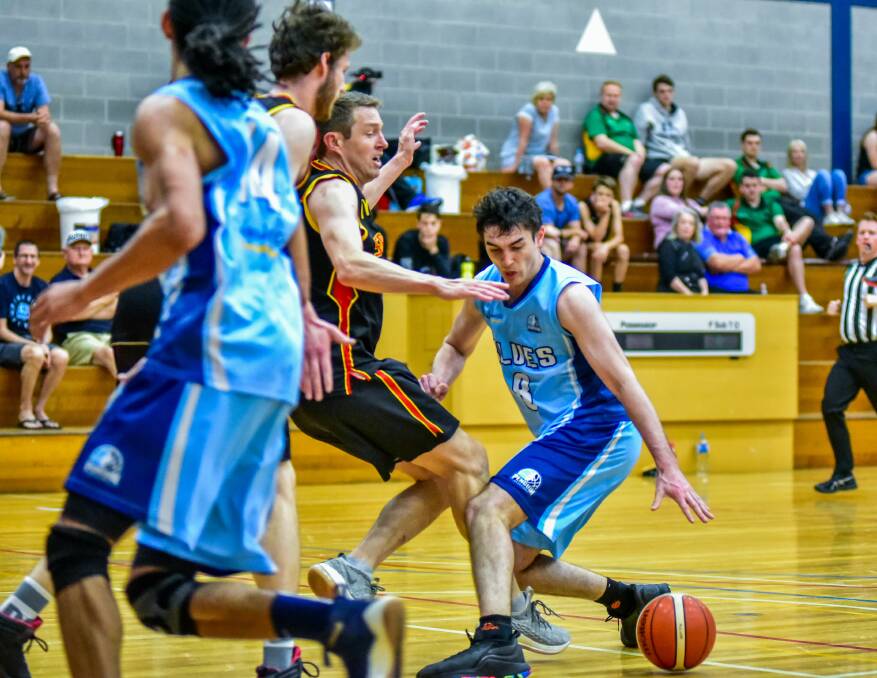 BALL CONTROL: Penguin guard Joe Chilcott reaches for the ball under stern defensive pressure from Glenorchy in the men's State League grand final. Pictures: Neil Richardson