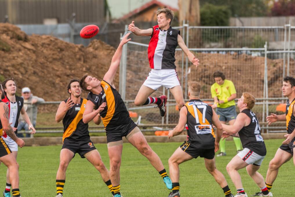 IN THE CLOUDS: High-flying Saint Nicholas Burt flies over the top of Longford opponent Connor Alexander in the NTFA division 1 match at Tigerland. Pictures: Phillip Biggs