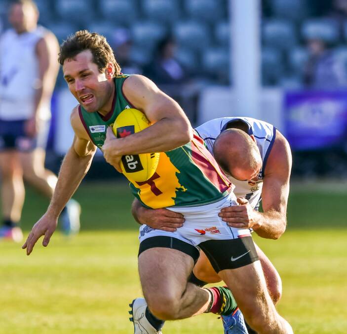 GOTCHA: Tasmanian favourite Tim Hazell attempts his best to break away from the determined tackle of the one-time, 125-game Fitzroy player Jason Baldwin. Picture: Phillip Biggs.