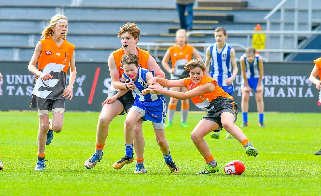 UNDER PRESSURE: Deloraine small man Noah Hill is held off the ball by a pack of East Coast Giants in Sunday's NTJFA under-14 division 2 grand final. Pictures: Scott Gelston