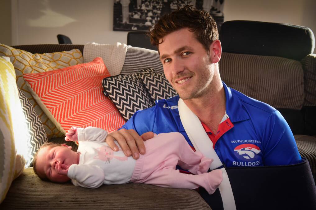 BONDING: Adam Viney connects with nine-day-old daughter Cait despite his arm being in a sling. Picture: Paul Scambler