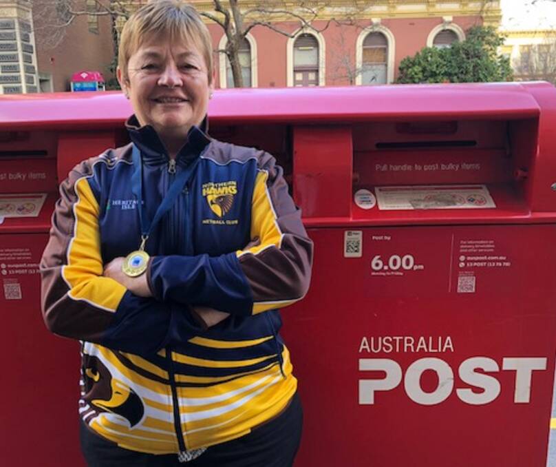 WINNER: Long-time Northern Hawks servant Ann Pearce could not remove the smile off her face or this year's State League premiership medal from around her neck on Monday back working at Australia Post. Picture: Andrew Mathieson