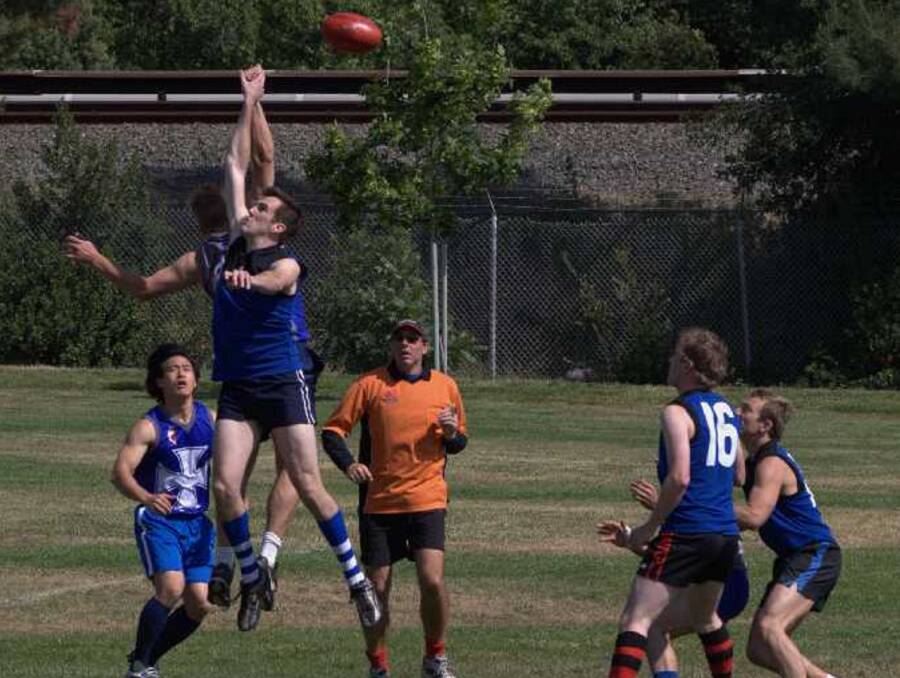 Whistleblower Barnes (in orange) takes control of a Golden Gate AFL match during a ball-up.