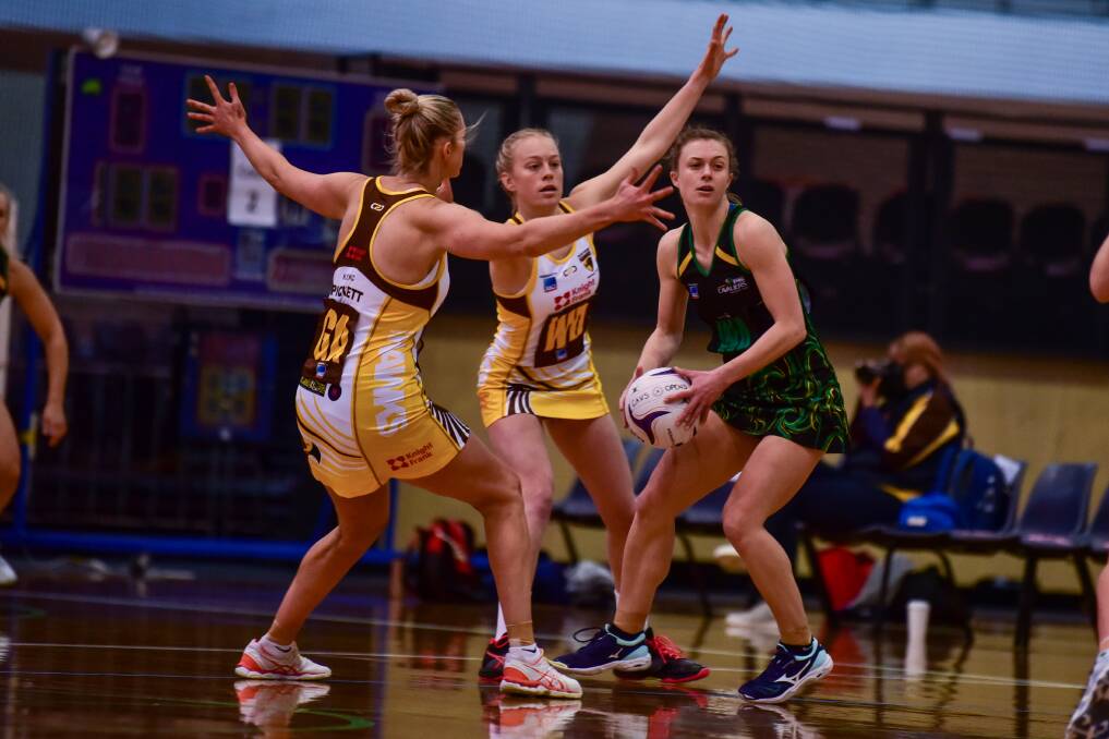 CONTEST: Northern Hawks pair Danni Pickett and Hannah Lenthall look to crowd the space of Cavaliers centre Lucy Dennis in the times of social distancing at Saturday's State League netball grand final rematch at the Silverdome. Picture: Neil Richardson