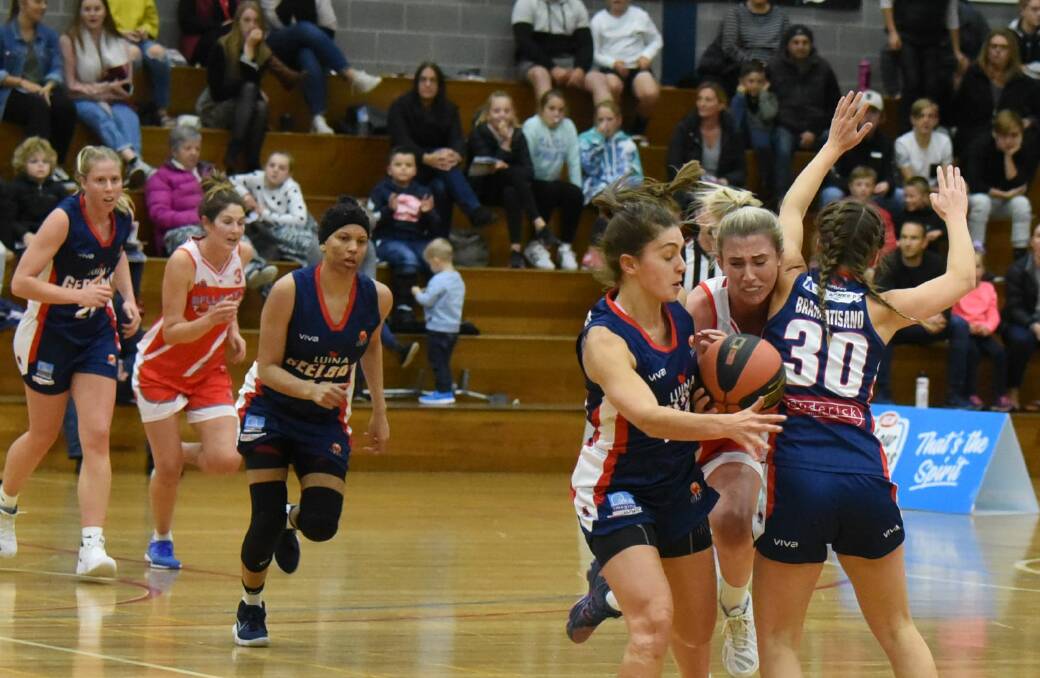 FEELING THE SQUEEZE: Lauren Nicholson looks to get passed two Supercats defenders.
