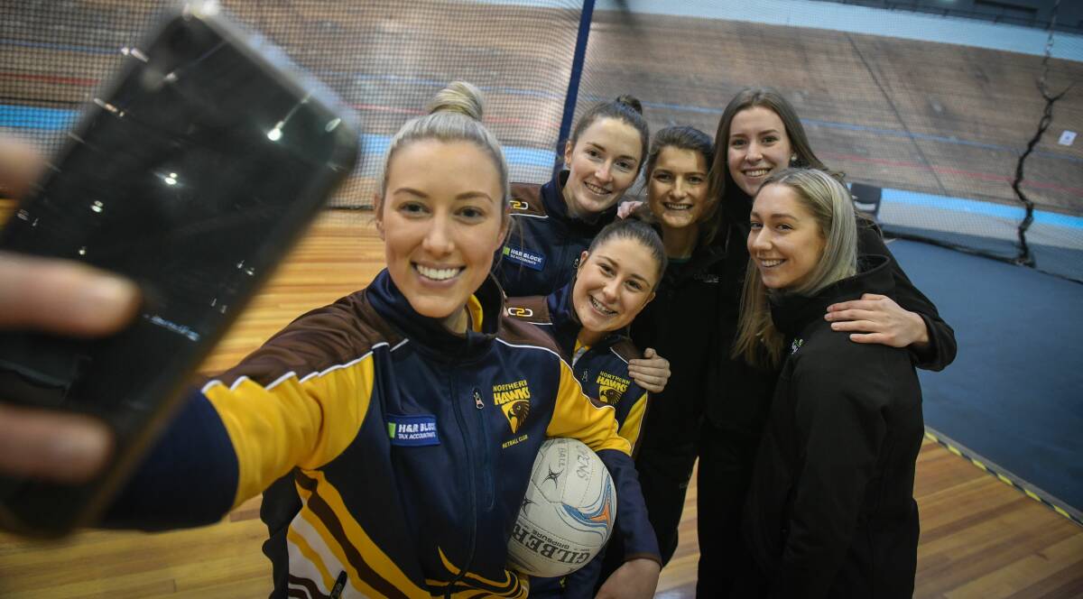 FRIENDS OR FOE: Danni Pickett snaps an image of Northern Hawks teammates and Cavaliers rivals before last year's grand final derby. Picture: Paul Scambler