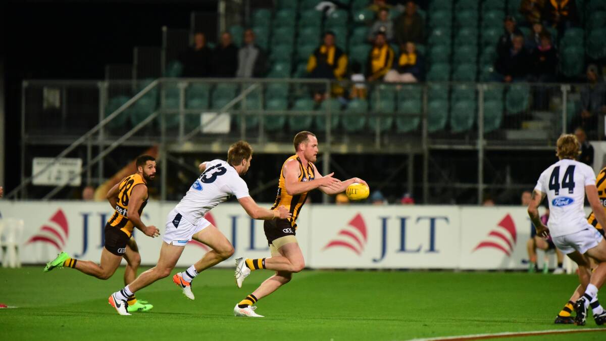 I'M BACK: Hawthorn superstar Jarryd Roughead gives veteran Cats defender Tom Lonergan the run around in his comeback to football in Launceston. Pictures: Paul Scambler