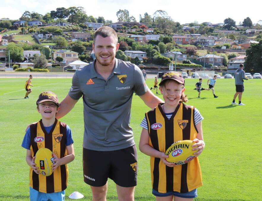 HAPPY TEAM: Hawthorn talent Blake Hardwick greets two Hawks fans amid a junior football super clinic at Windsor Park on Sunday. Picture: Supplied