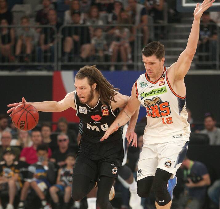DANCE: Former Cairns Taipans veteran Lucas Walker gets tangled up with Melbourne United championship player Craig Moller. Picture: AAP