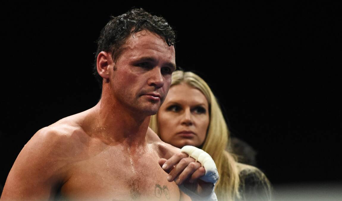 TOUGH LOVE: Daniel Geale is consoled by his wife after his loss to Quinlan. Picture: Scott Gelston
