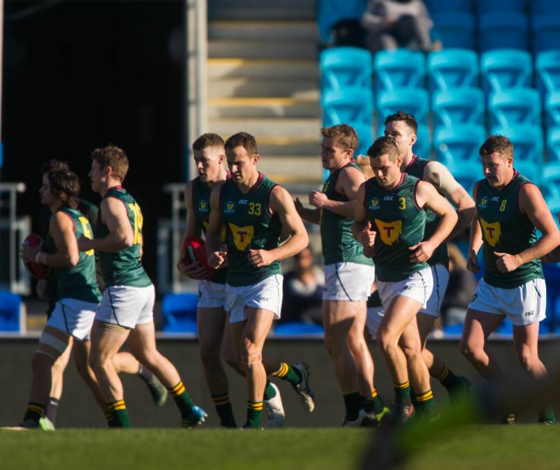 FRONT AND CENTRE: Jay Lockhart (left) helps lead Tasmania onto Bellerive Oval to face the NEAFL side. 