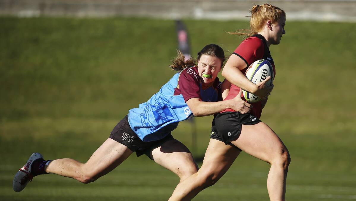 BURST AWAY: UTAS Lions captain Lauryn Cooper looks to brush aside a University of Queensland tackler during the first round of this year's National University Sevens Series in Hobart over the weekend. Pictures: Karen Watson