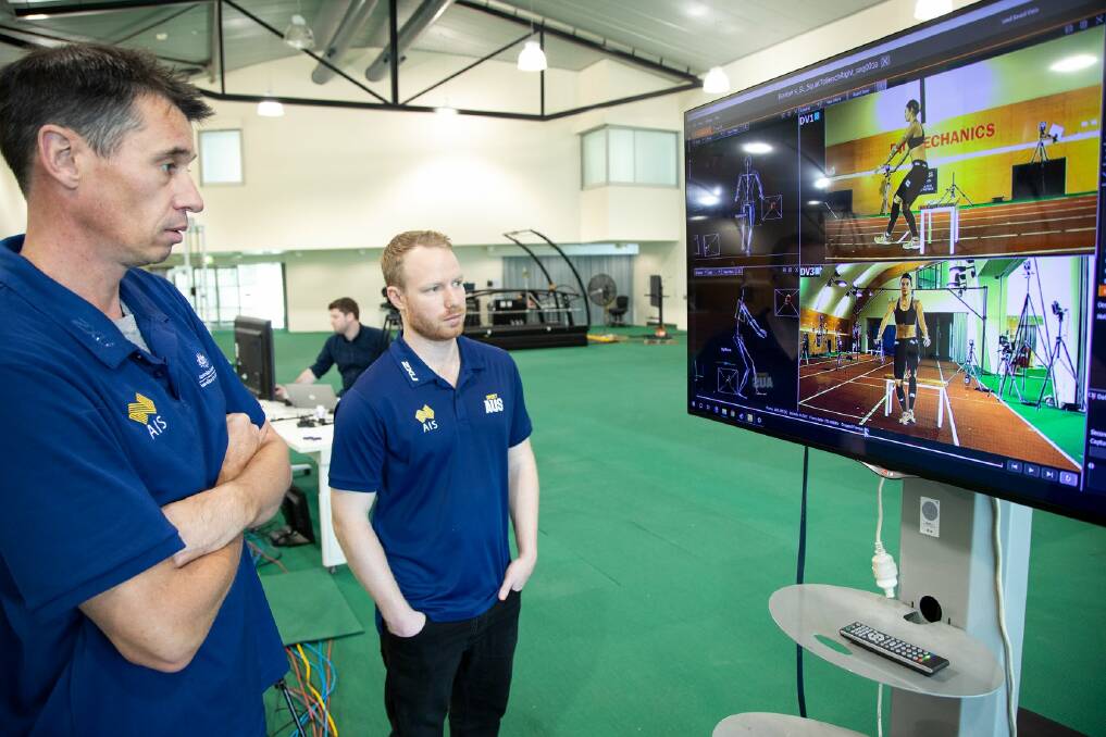 ON THE JOB: AIS strength and conditioning Aaron Holt, left, watches vision of one of his athletes. Picture: Supplied.
