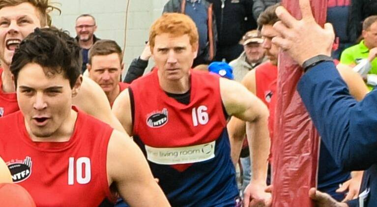FIERCE: Retiring redhead Andrew McLean shows a steely resolve running into Lilydale's banner. Picture: Phillip Biggs