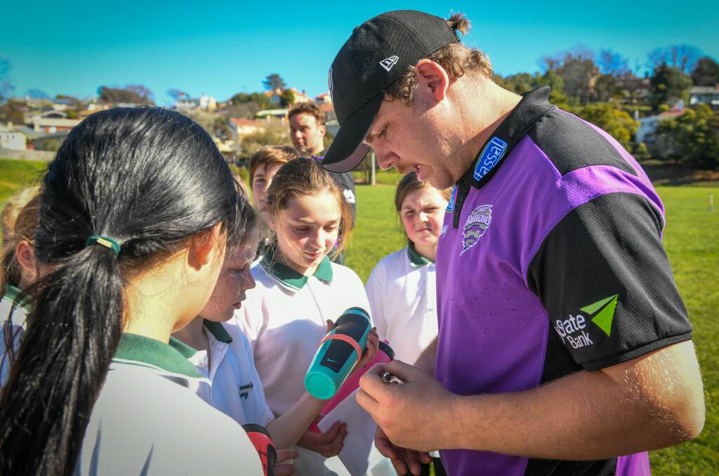 KING OF THE KIDS: A group of East Launceston primary school children swamp Freeman for an autograph.