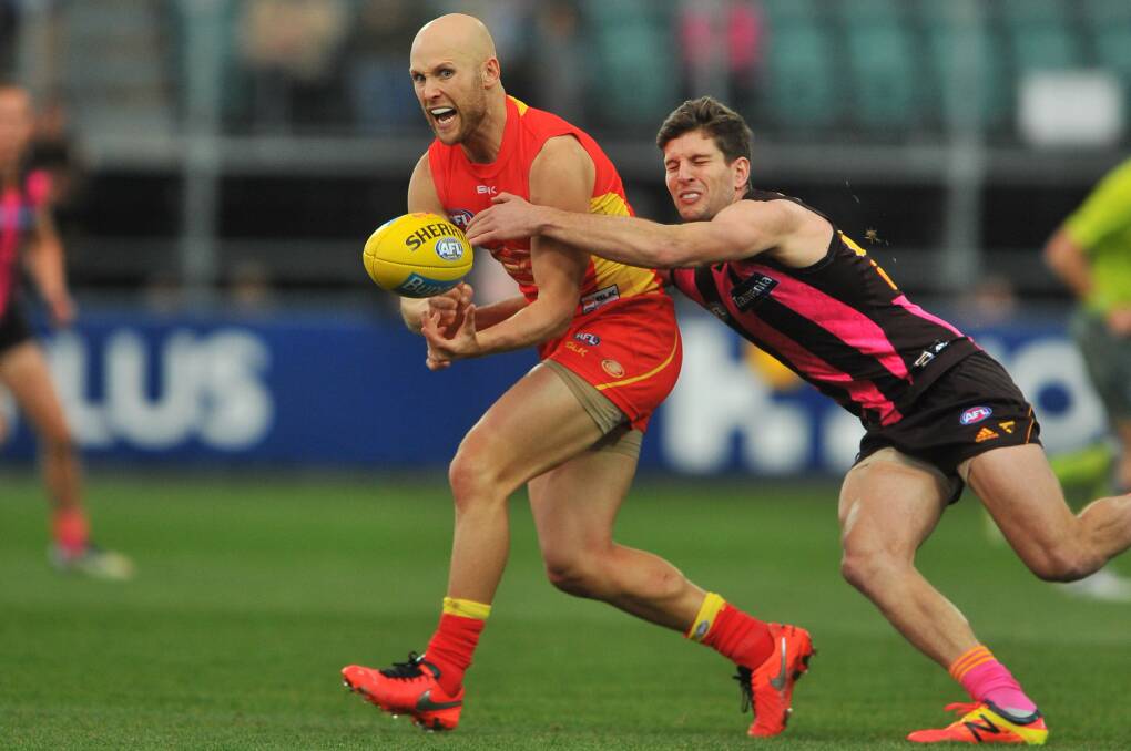 MASTER CLASS: Gary Ablett looks to evade the tackle of Luke Breust in the former Gold Coast captain's last match in Launceston against Hawthorn.