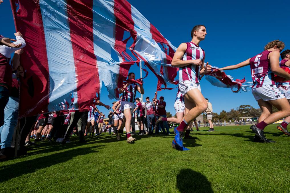 ALL IN: Triumphant Hillwood run through the banner on grand final day last year. Picture: Phillip Biggs