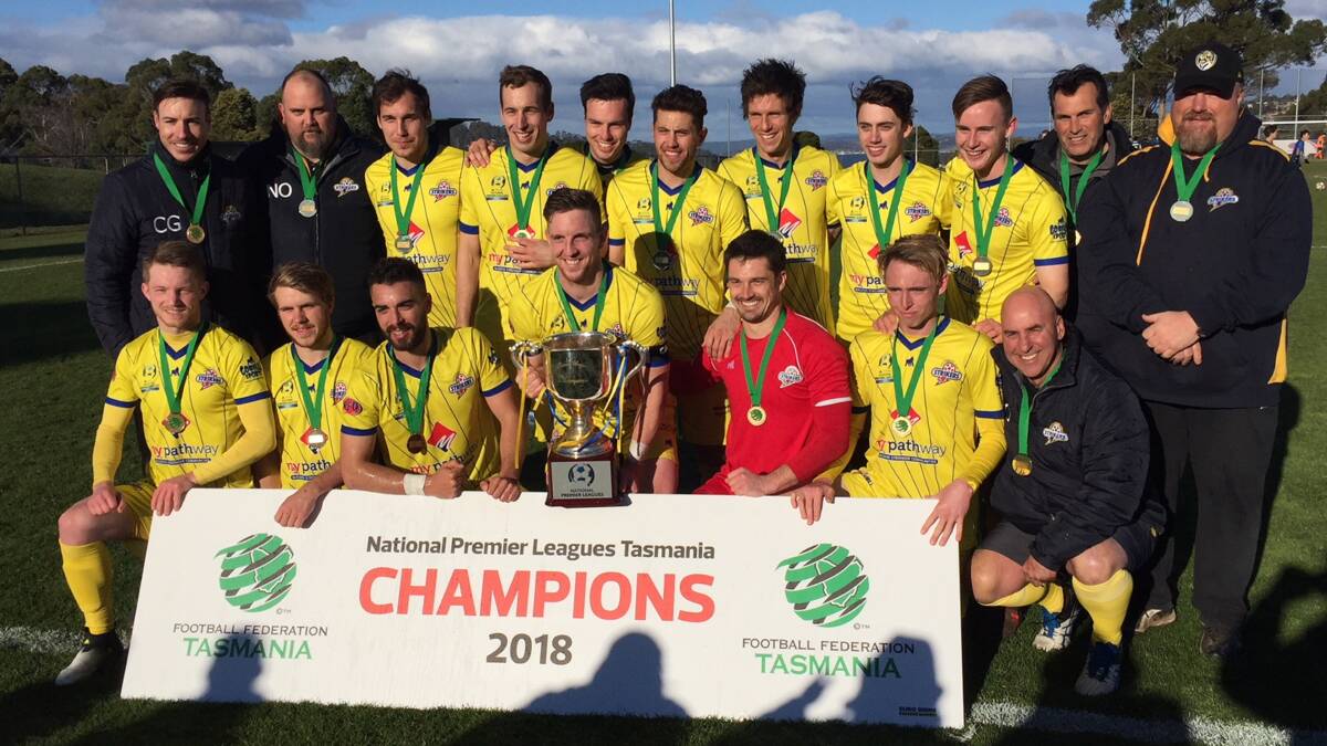 WINNING SMILES: Devonport City celebrate with silverware and sign in tow after claiming the 2018 NPL Tasmania title on Saturday. Picture: Brad Cole