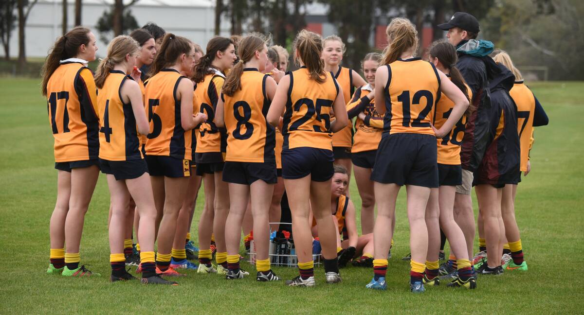 ALL EARS: Scotch Oakburn College players listen up to team instructions during a quarter-time break.