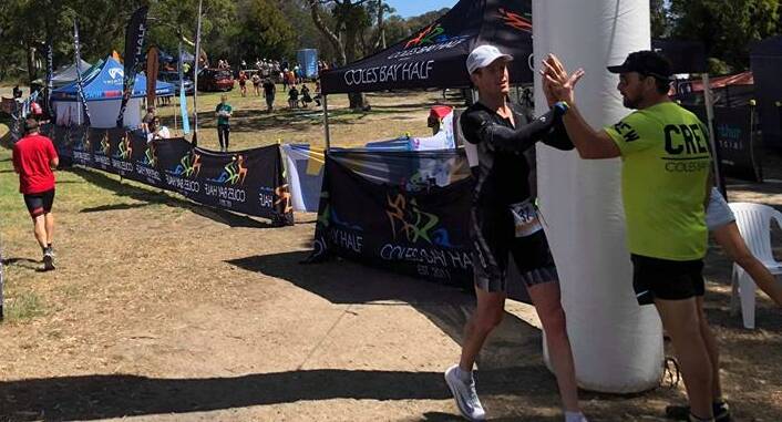STAR: Winner Ali Foot is congratulated across the line of the Coles Bay Half ironman on Saturday. Picture: Supplied 