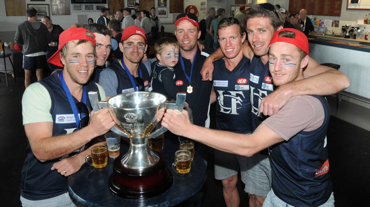 CUP GLORY: Members of the 2011 TSL premiership side celebrate with the club's last significant trophy.