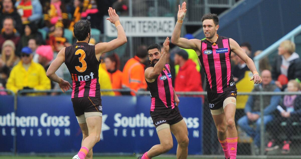 HIGH FIVES ALL ROUND: Jack Gunston, Paul Puopolo and Jordan Lewis join the celebrations during Hawthorn's win over Gold Coast at Aurora Stadium. Picture: Scott Gelston  
