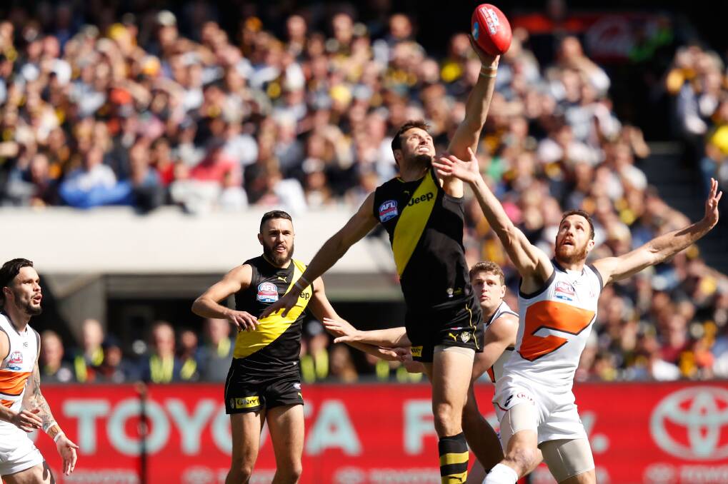 BIG MAN FLY: Richmond follower Toby Nankervis jumps well above Giant Shane Mumford in the centre square battle at the MCG. Picture: AFL Photos