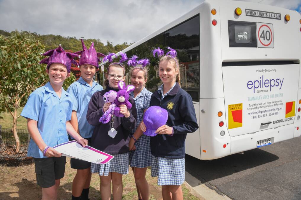 GOING PURPLE: Trevallyn Primary students James Watson 10, Harry Blyth 11, Sophie Schilg 11, Amy Lovegrove 10 and Heidi Curtis 12 in front of 'Miss Lila', a bus named in support of children with epilepsy. Picture: Paul Scambler.