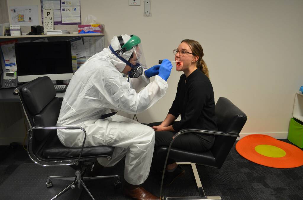 CALLING FOR MORE: Dr Jerome Muir Wilson believes more testing will help slow the potential spread of coronavirus in Tasmania. He is pictured demonstrating testing with Mel Archer. Picture: Ryan Young