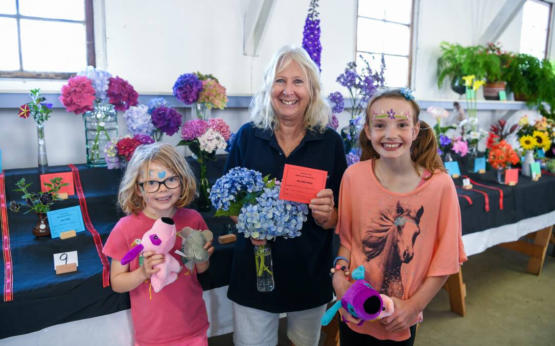 FUN DAY: Exeter Show Society spokeswoman Hilary Keeley with Maeve and Freya McEvoy, and her hydrangeas which won second prize at the Exeter Show on Saturday. Picture: Neil Richardson