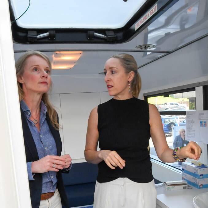 Health Minister Sarah Courtney and infectious disease specialist Professor Katie Flanagan in a dedicated coronavirus testing bus.