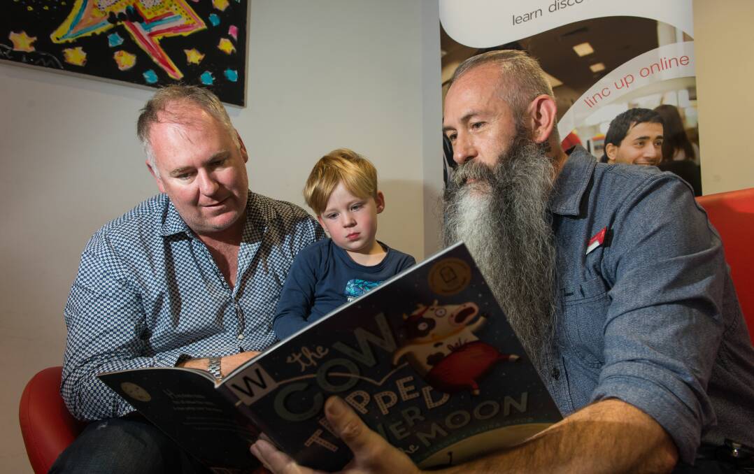 STORY TIME: Henry Mackenzie, 3, and his dad Andrew Mackenzie get a glimpse into what to expect next Wednesday as LINC Launceston manager Garry Conroy-Cooper gives them a special preview. Picture: Phillip Biggs.