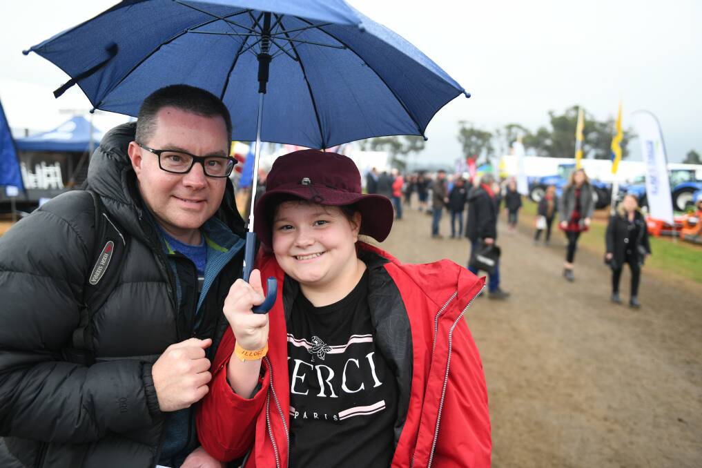 SHELTER: Enjoying the day one of Agfest despite the rain are Adam Jacobson and his daughter Matilda. Pictures: Paul Scambler 