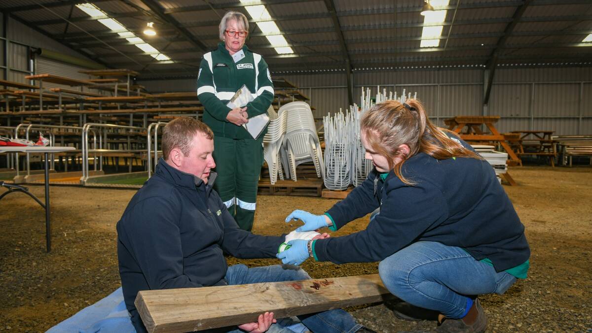 Winner: Ashley Evans of Nubeena puts bandages on patient Jake Williams, watched by Jane McCann of St John Ambulance in the first aid module. Picture: Paul Scambler.