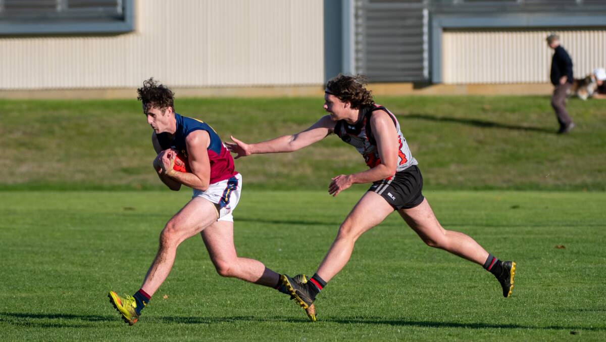 CHEST MARK: Old Scotch's Clay Ritchie takes a mark in front of UTAS' Zac Bott at University Oval.