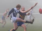 MOVING IT FORWARD: Old Launcestonians captain Campbell Fraser kicks past Evandale's Sebastian Woof during the match played in foggy conditions. Picture: Phillip Biggs