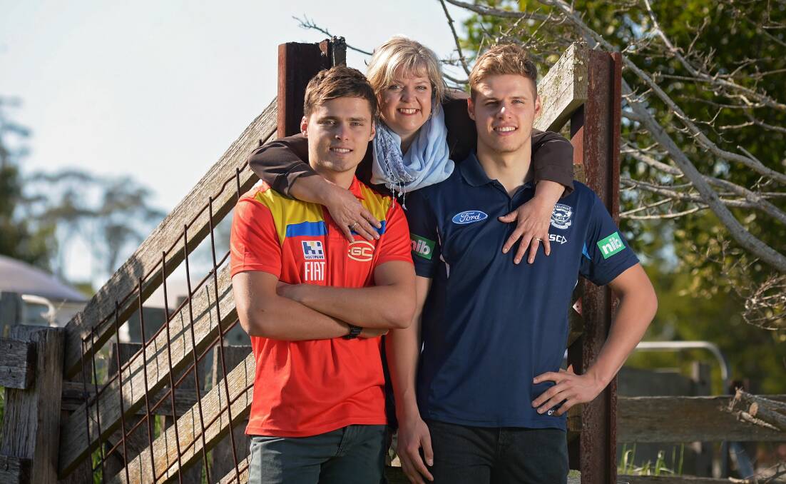 Twins Kade and Jake Kolodjashnij and their mum Sharon at their home near Longford in 2015. The brothers were drafted to the AFL in 2013. Picture by Phillip Biggs